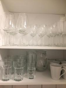 a bunch of glasses sitting on a shelf at City Appartment Krefeld - 20 km DUS Airport/Messe in Krefeld