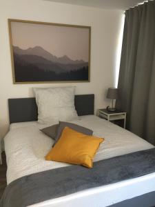 a bed with a yellow pillow on top of it at City Appartment 1 Krefeld 20 km DUS Airport Messe in Krefeld