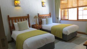 a hotel room with two beds and a window at Kruger Park Lodge - AM8 - 3 Bedroom Chalet in Hazyview +28 photos