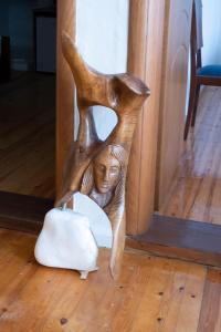 a wooden chair with a statue of a woman and a cat at Kavala Rooms in Kavala