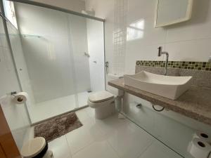 a white bathroom with a sink and a toilet at Hotel APART Zuccolotto 303 in Aracruz