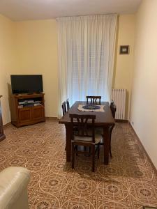 - un salon avec une table, des chaises et une télévision dans l'établissement De Nicolò Home, à Putignano