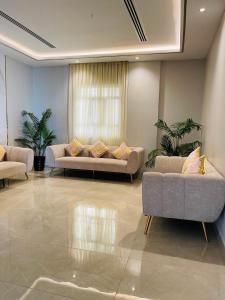 a living room with two couches and a window at Husin Al Khaleej Hotel Apartment in Seeb
