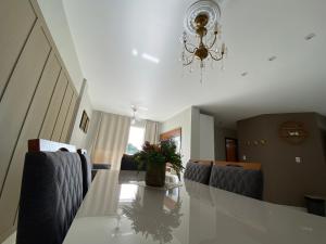 a dining room with a table and chairs and a chandelier at Hotel APART Zuccolotto 303 in Aracruz
