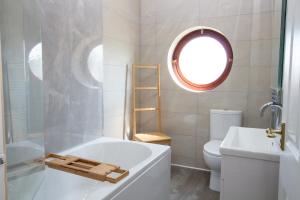 een badkamer met een bad, een toilet en een raam bij Beautiful townhouse in leafy suburb of Bradshaw in Bradshaw