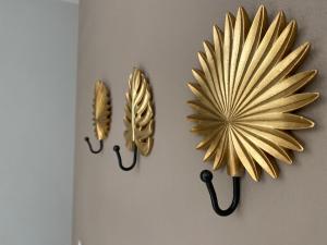 two gold fan shaped mirrors hanging on a wall at Hotel APART Zuccolotto 303 in Aracruz