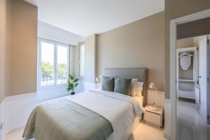 sypialnia z dużym łóżkiem i oknem w obiekcie Apartamento Embajadores XVII w Madrycie