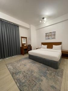 um quarto com uma cama grande e uma janela em Husin Al Khaleej Hotel Apartment em Seeb