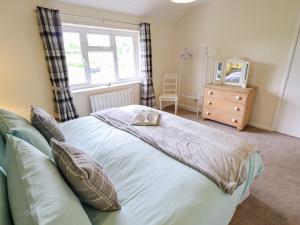 a bedroom with a bed and a window and a dresser at 6 Hillside Cottages in Gainsborough