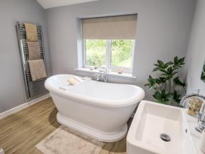 a white bathroom with a tub and a sink at 6 Hillside Cottages in Gainsborough +23 photos