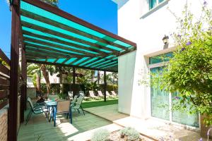 a pergola over a patio with a table and chairs at Villa Natalie in Protaras