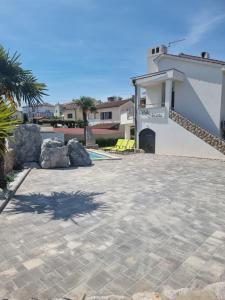 a patio with rocks and a building with a house at Villa Marta in Porat
