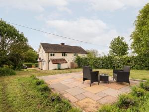 a patio with two chairs and a table in front of a house at 6 Hillside Cottages in Gainsborough