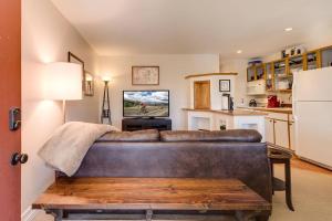 a living room with a brown couch and a kitchen at Cozy Red Roost Residence Essential Getaway in Breckenridge