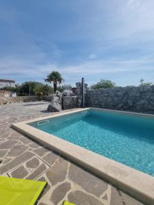 a swimming pool with a stone wall and a swimming poolitures at Villa Marta in Porat