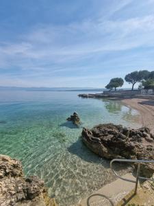 a beach with clear water and rocks and trees at Villa Marta in Porat