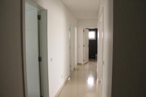 an empty hallway with white walls and a mirror at Gold Apartment Baleal in Ferrel