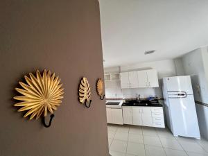 a kitchen with white cabinets and a white refrigerator at Hotel APART Zuccolotto 303 in Aracruz