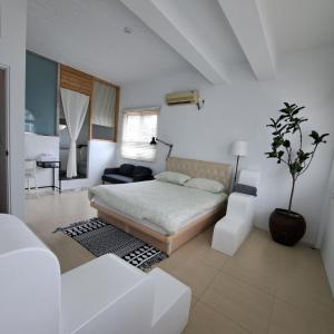 um quarto com uma cama, um sofá e uma mesa em Maluda B&B em Taimali