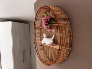 a wicker shelf with a white cat on a wall at Hotel APART Zuccolotto 303 in Aracruz