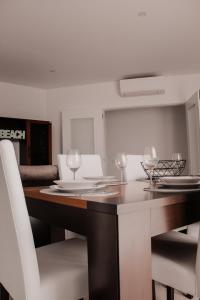 una mesa de comedor con sillas blancas y copas de vino en Gold Apartment Baleal, en Ferrel 30 fotos más