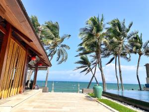 Sunsea Resort في موي ني: منتجع فيه نخل بجوار المحيط