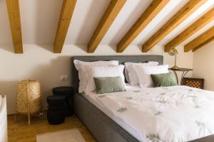 Villa Mara- Casa Rustica في كورتْشولا: غرفة نوم بسرير ومخدات بيضاء وأخضر