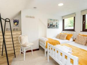 a small bedroom with two beds and a chair at Aryarch in Eglingham