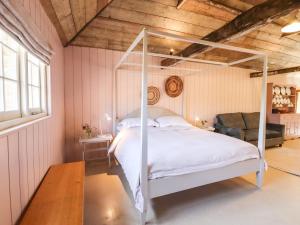 een slaapkamer met een hemelbed op zolder bij The Stone Barn in Ticehurst