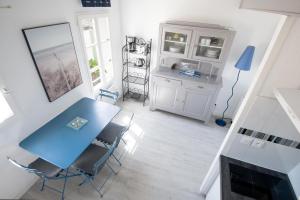 een eetkamer met een blauwe tafel en stoelen bij Studio "Palombe" dans résidence avec piscine in Saint-Martin-de-Ré