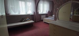 a bedroom with a couch and a mirror and a dresser at Pink House Dziwnów 250 m od Morza in Dziwnów