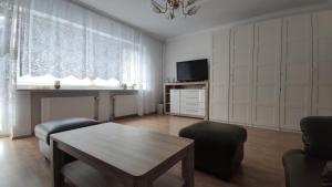 a living room with a table and a tv at MIESZKANIE - DOM 200 m od MORZA in Dziwnów