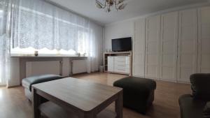 a living room with a table and a tv at Pink House Dziwnów 250 m od Morza in Dziwnów