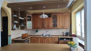 a kitchen with wooden cabinets and a sink at Pink House Dziwnów 250 m od Morza in Dziwnów
