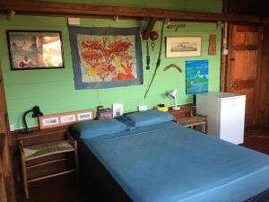 Schlafzimmer mit einem blauen Bett und einem Kühlschrank in der Unterkunft Large Cottage Rodney Bay 2 bedrooms 2 bathrooms in Gros Islet