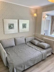 a bed in a bedroom with two pictures on the wall at Downtown Studio - Ultra Central with Park View in Bucharest