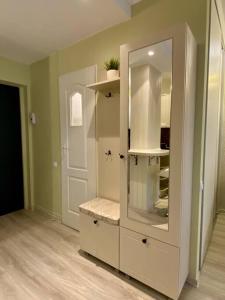 a white cabinet with a mirror in a room at Downtown Studio - Ultra Central with Park View in Bucharest