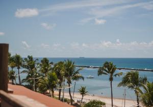 a view of a beach with palm trees and the ocean at Hotel Ponta Verde Praia do Francês in Praia do Frances