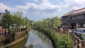 ein Fluss in einer Stadt mit Gebäuden und einem Auto in der Unterkunft 農家古民家ねこざえもん奥屋敷 Nekozaemon-Gest house in Nishiwada