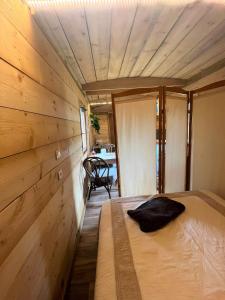 a bedroom with a bed in a room with wooden walls at La Cabane de Mercone Crenu in Corte