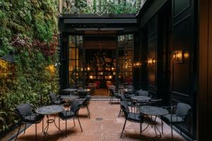 a patio with tables and chairs in a restaurant at Wittmore Hotel - Adults Only in Barcelona