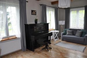 een woonkamer met een piano en een bank bij Dom Podcieniowy na Żuławach Wiślanych in Nowy Dwór Gdański