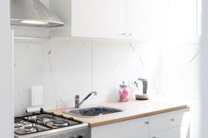 a white kitchen with a sink and a stove at Apartment Ivka in Osijek