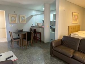 a living room with a couch and a table and a kitchen at Luzon Residence Apartments in Fortaleza