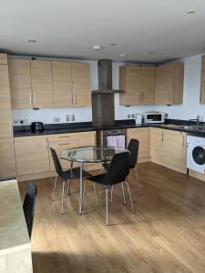 a kitchen with a glass table and chairs in it at 2 Bed 2 baths Apt in Stratford in London