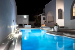 una piscina en una villa por la noche en Alloro Perissa, en Perissa
