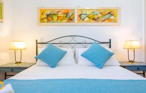 una camera da letto con un letto con cuscini blu e 2 lampade di Villa Luritu Luxury Pool Tricase by HDSalento a Tricase