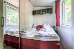 uma cama num quarto com um espelho em Gecko - The Tiny House em Landau in der Pfalz