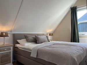 een slaapkamer met een bed en een raam bij Villa Lighthouse in Callantsoog