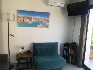 une chambre avec une chaise bleue et un tableau sur le mur dans l'établissement Chez Ramses, à Marseille